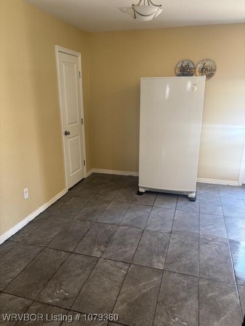 unfurnished room with baseboards