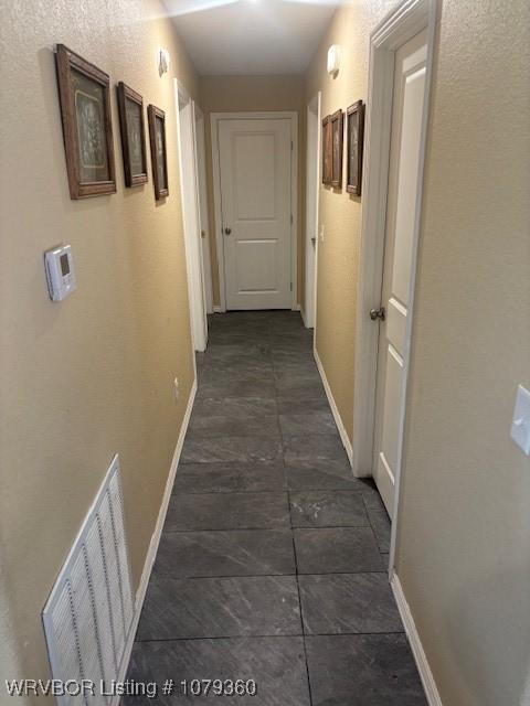 hallway featuring visible vents and baseboards