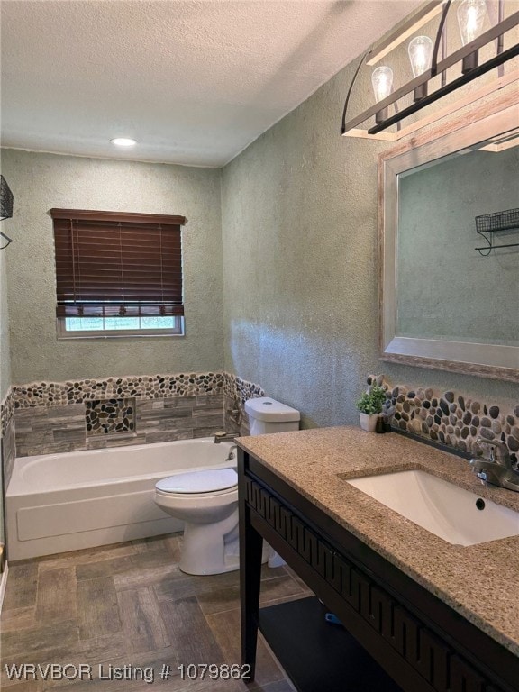 full bath featuring a textured ceiling, a bathing tub, toilet, vanity, and a textured wall