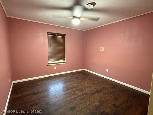 empty room featuring dark wood-type flooring, ornamental molding, baseboards, and a ceiling fan