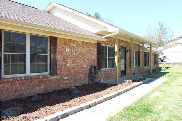 view of side of property with brick siding and a shingled roof