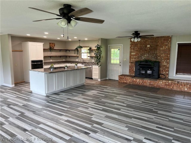 1611 Kimberling Hill Dr, Alma, AR 72921 - kitchen featuring open shelves, black oven, dishwasher, a ceiling fan, and wood finished floors