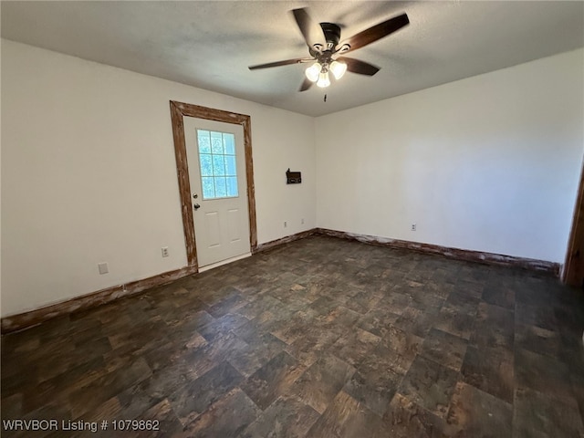 spare room with baseboards and ceiling fan
