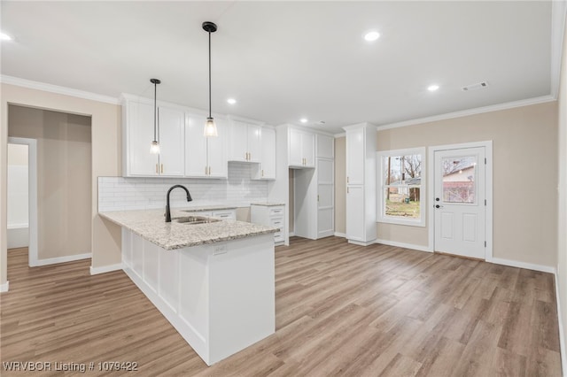 3115 Spradling Ave, Fort Smith, AR 72904 - kitchen featuring a peninsula, crown molding, light wood-style flooring, white cabinetry, and backsplash