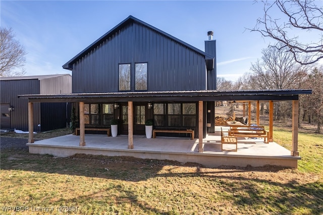 rear view of property featuring a yard and a patio