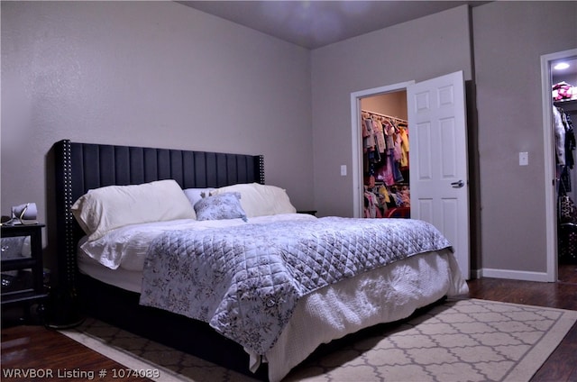 bedroom with dark hardwood / wood-style flooring, a spacious closet, and a closet