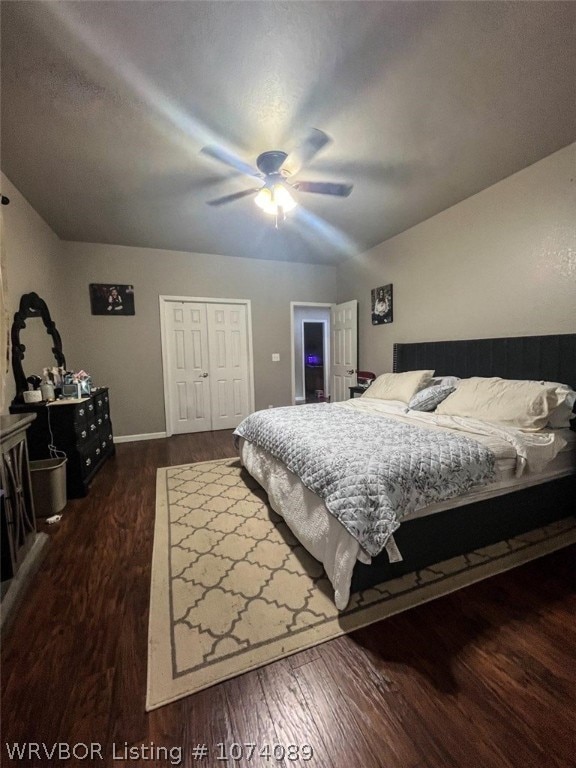 bedroom featuring vaulted ceiling, ceiling fan, a closet, and dark hardwood / wood-style floors