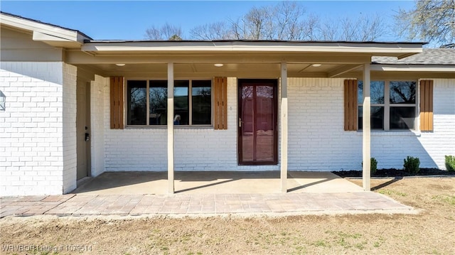 view of exterior entry with brick siding