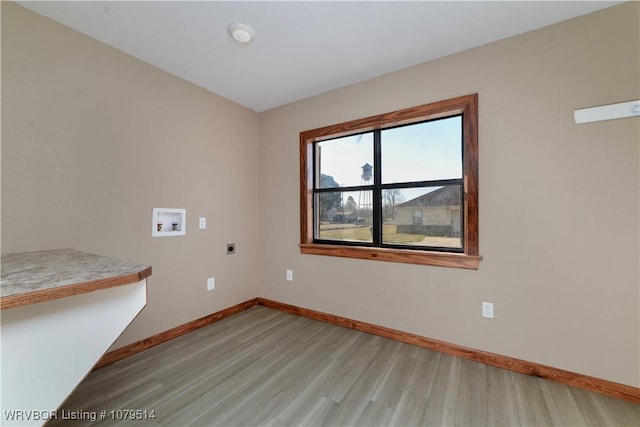 spare room with light wood finished floors and baseboards