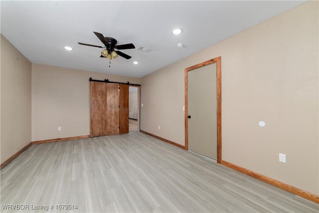 empty room featuring baseboards, visible vents, a ceiling fan, and light wood-style floors