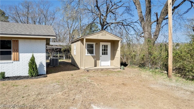 view of shed featuring central AC unit and fence