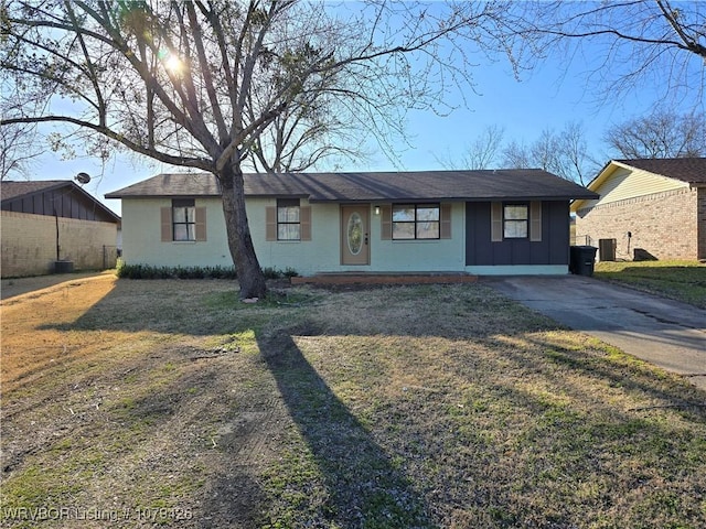 single story home with board and batten siding, cooling unit, and a front lawn