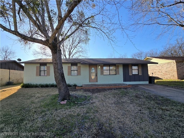 ranch-style home featuring a front lawn, board and batten siding, and brick siding