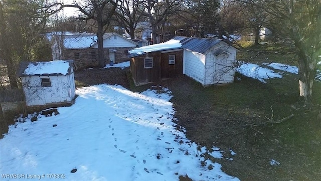 yard layered in snow featuring a storage unit