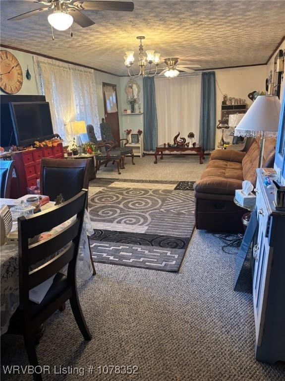 carpeted living room with ceiling fan with notable chandelier and a textured ceiling