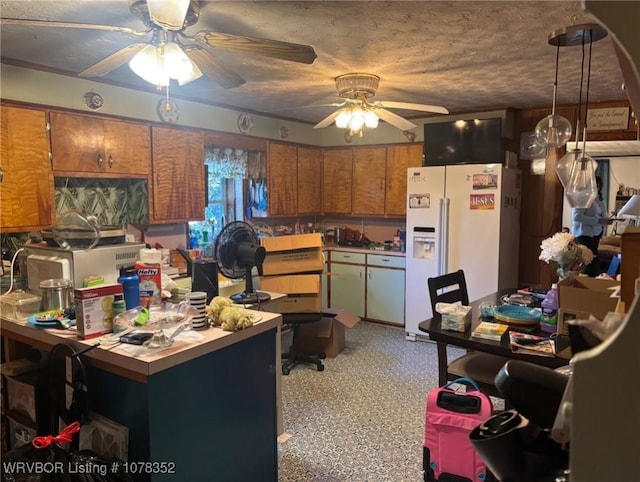 kitchen with ceiling fan, white refrigerator with ice dispenser, and a textured ceiling