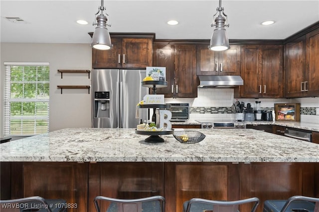 298 Bayou Rd, Fort Gibson, OK 74434 - kitchen with decorative backsplash, dark brown cabinetry, under cabinet range hood, stainless steel refrigerator with ice dispenser, and light stone counters