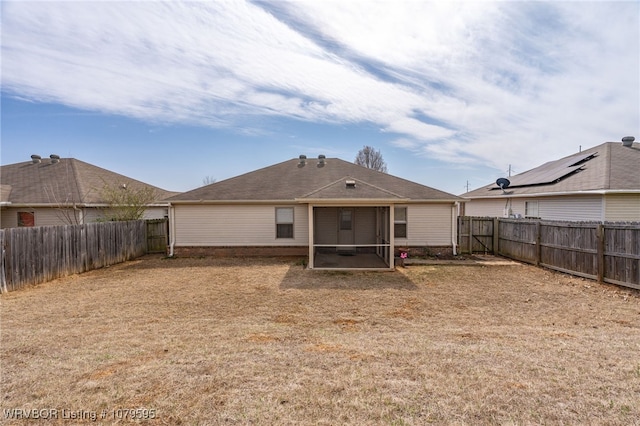 rear view of property with a fenced backyard and brick siding