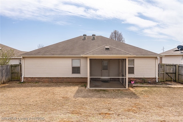 back of property featuring a fenced backyard, a sunroom, and roof with shingles