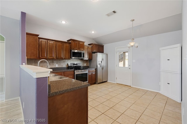 kitchen featuring visible vents, a sink, backsplash, stainless steel appliances, and lofted ceiling