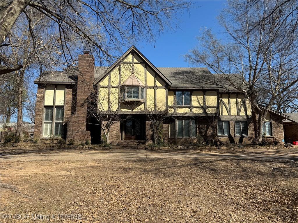 view of front of house featuring stucco siding and a chimney