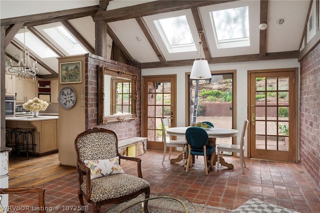 sunroom with vaulted ceiling with skylight, a notable chandelier, and a wealth of natural light