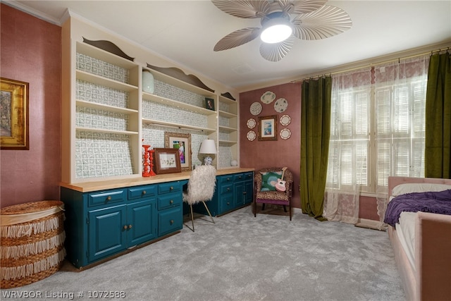 carpeted office space with ceiling fan, built in desk, built in features, and crown molding