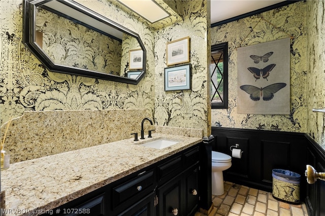 bathroom with vanity, toilet, and ornamental molding