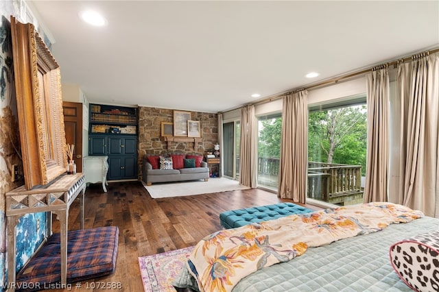 bedroom with dark hardwood / wood-style flooring, a fireplace, and access to outside