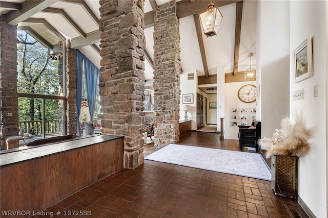 foyer entrance with beam ceiling, high vaulted ceiling, and a wealth of natural light