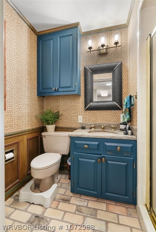 bathroom with crown molding, vanity, an enclosed shower, and toilet