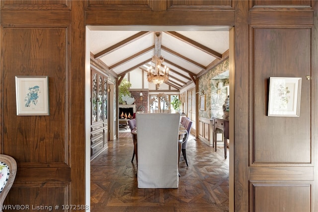 dining area with a chandelier, dark parquet floors, and lofted ceiling with beams