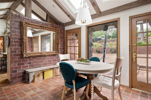 dining space with vaulted ceiling with beams and brick wall