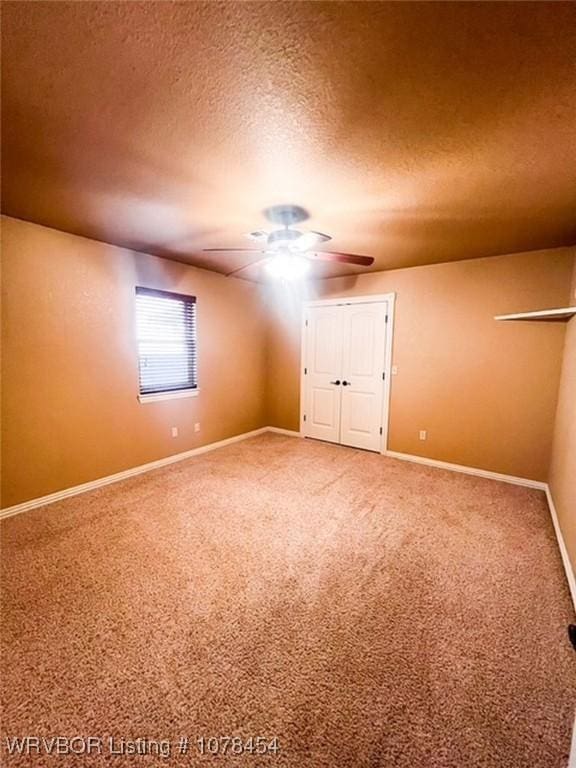 unfurnished bedroom with ceiling fan, carpet floors, and a textured ceiling