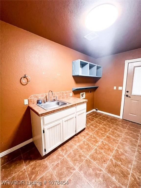 washroom featuring washer hookup, cabinets, and sink