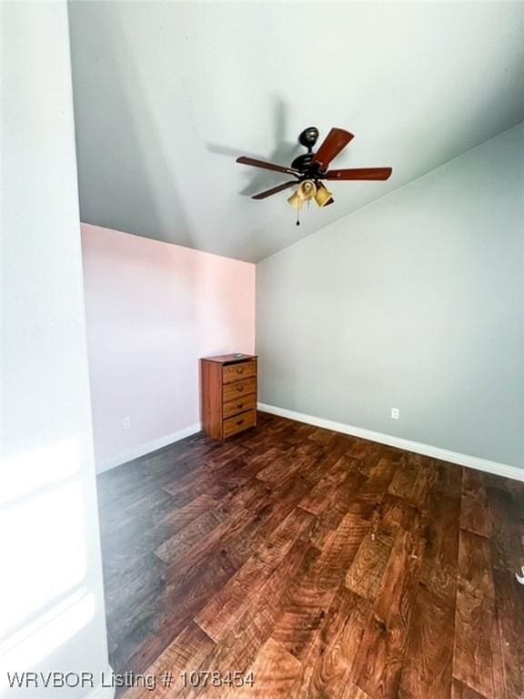 empty room with ceiling fan, dark wood-type flooring, and lofted ceiling