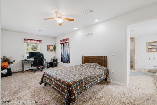 bedroom featuring ceiling fan, light colored carpet, and ensuite bathroom