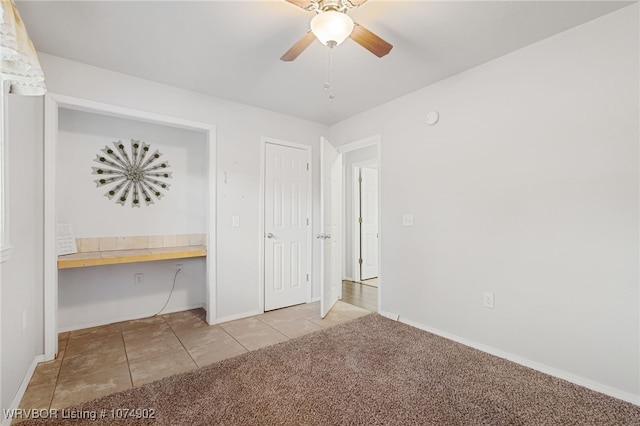 unfurnished bedroom featuring ceiling fan, a closet, and light carpet