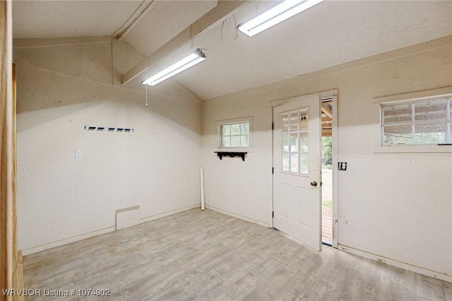 empty room with hardwood / wood-style flooring and lofted ceiling