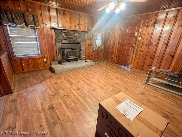 unfurnished living room featuring wood ceiling, wooden walls, and light hardwood / wood-style floors