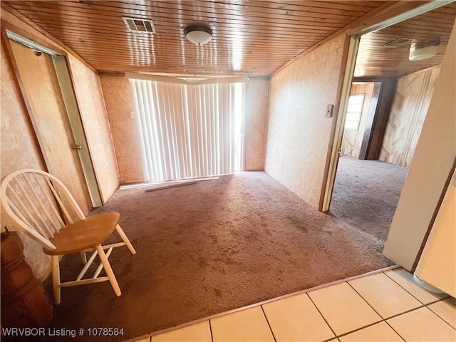 spare room featuring wood ceiling and light colored carpet