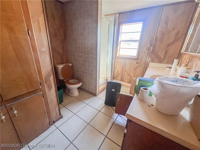 bathroom with vanity, a shower, tile patterned floors, toilet, and wood walls