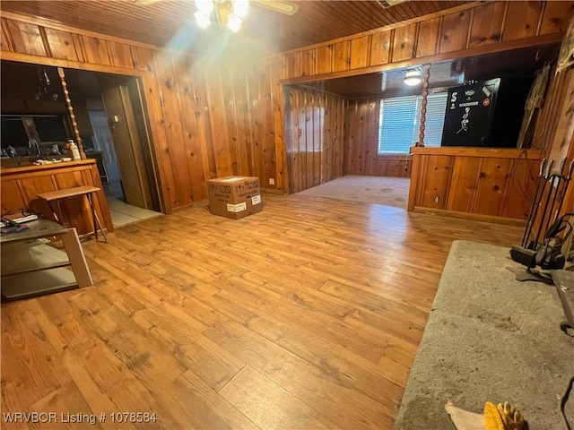 living room featuring wood ceiling, light hardwood / wood-style flooring, and wood walls