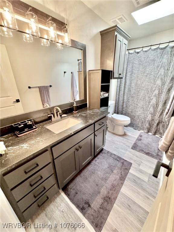 bathroom with vanity, hardwood / wood-style flooring, and toilet