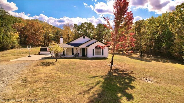 ranch-style house featuring a front yard and covered porch