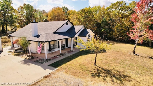 exterior space featuring covered porch and a yard