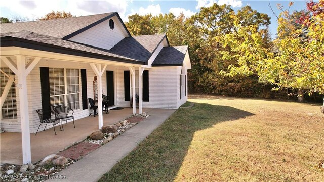 view of side of home with a yard and a porch