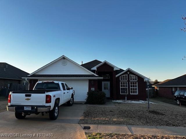 single story home with driveway and a garage