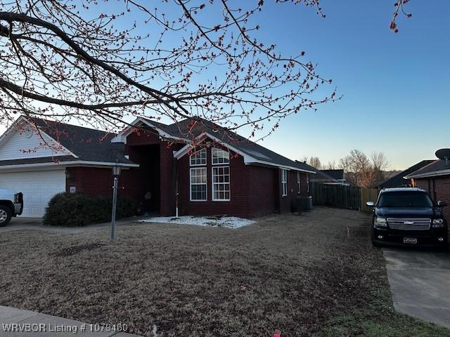 view of front of home featuring central AC, an attached garage, and fence