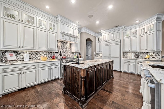 8200 Mile Tree Dr, Fort Smith, AR 72903 - kitchen featuring white cabinets, arched walkways, premium appliances, a sink, and dark wood-style floors